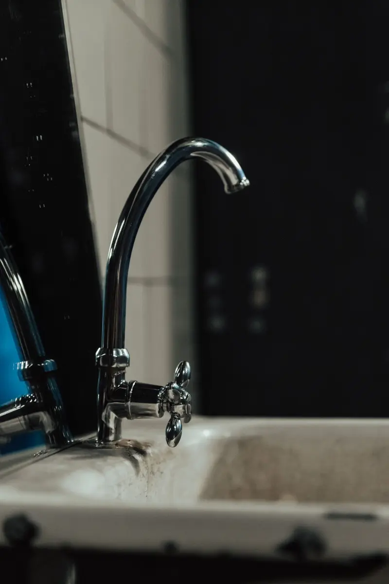 Old-fashioned bathroom sink with a chrome faucet and vintage tiles